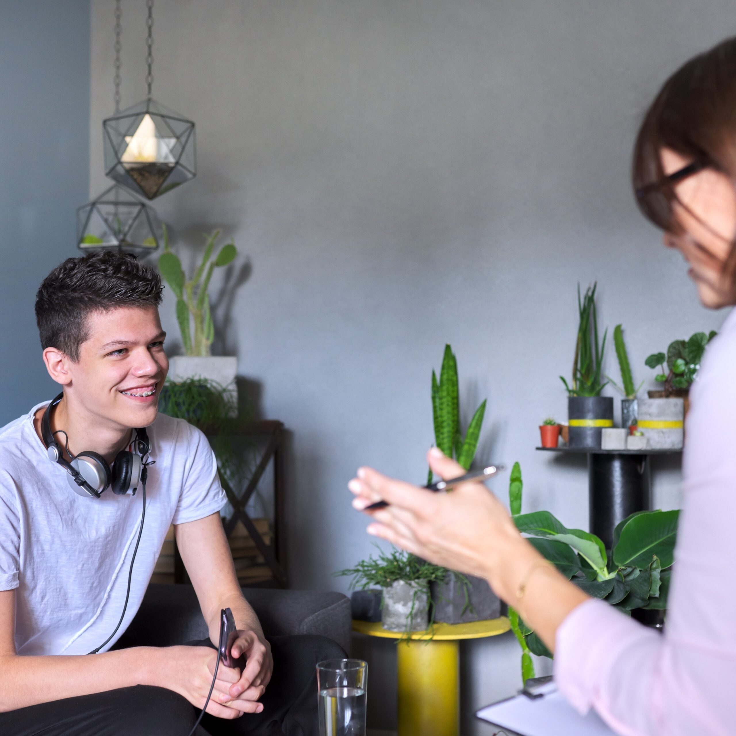 Teen boy talking to psychologist, individual therapy session for teenage with doctor