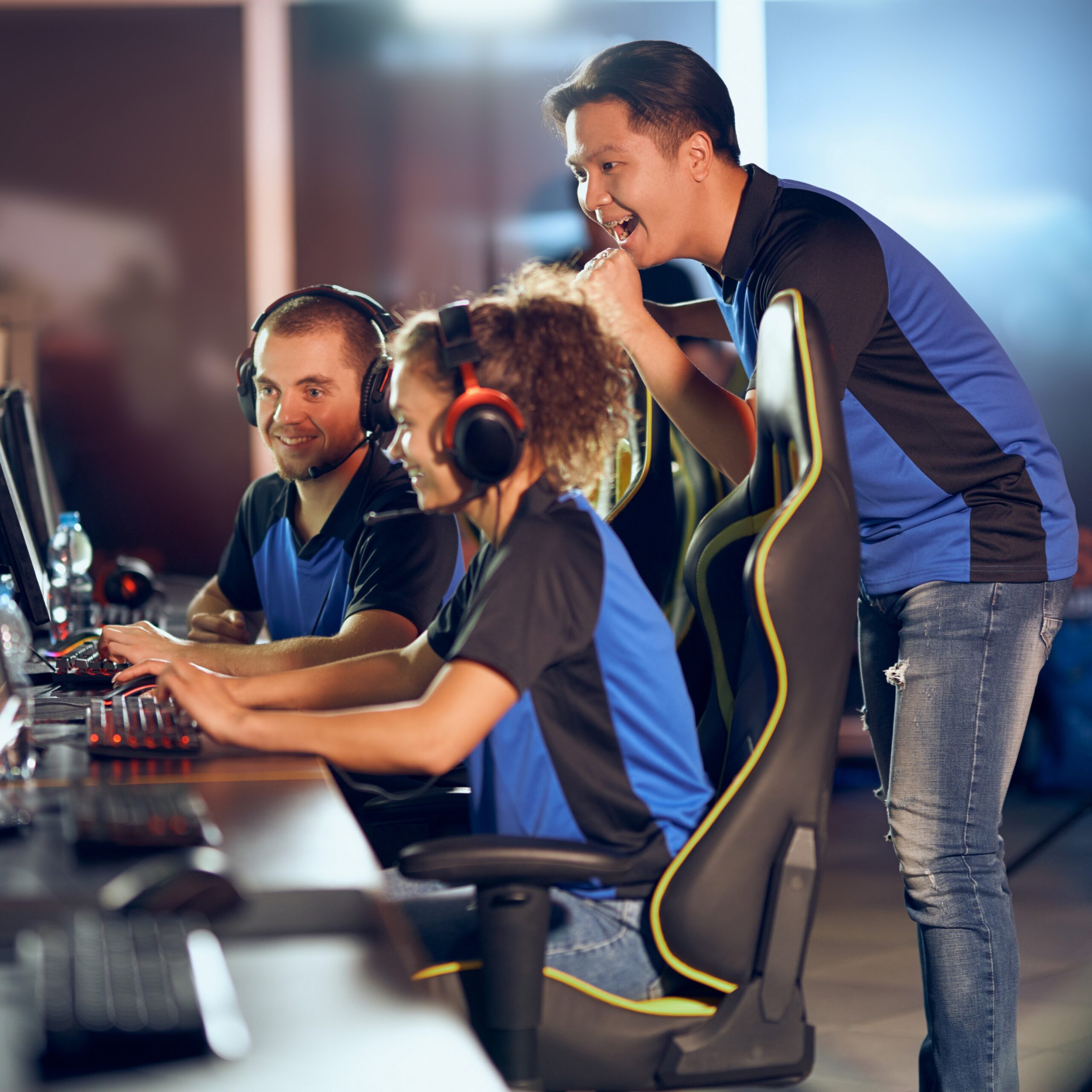 Celebrating success. Team of professional teenage cyber sport gamers participating in eSports tournament
